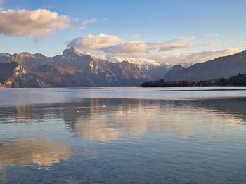 Scenic view of lake by mountains against sky