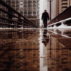 Surface level of man walking on wet footbridge