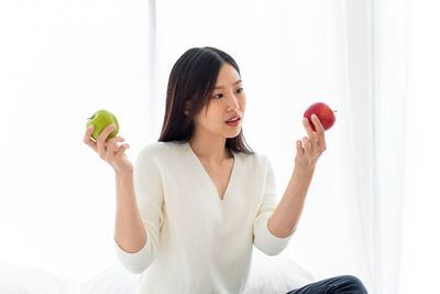 Young woman sitting on apple