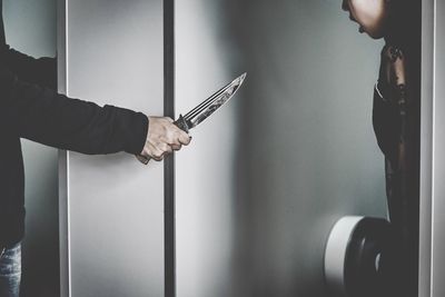 Cropped image of thief showing knife to woman