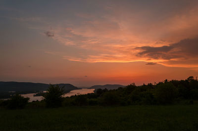 Scenic view of silhouette field against romantic sky at sunset