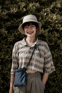 Portrait of smiling girl standing against plants