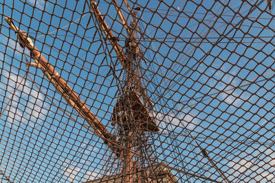 Low angle view of chainlink fence against sky