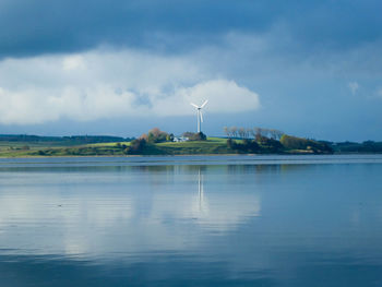 Wind mill reflected in calm sea