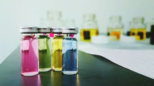 Close-up of colorful liquids in glass bottles on table