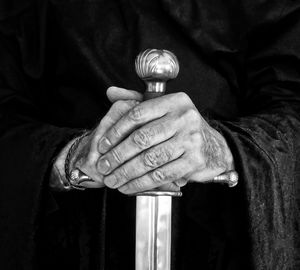 Close-up of man holding sword in darkroom