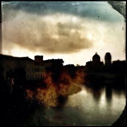 Buildings against cloudy sky at dusk