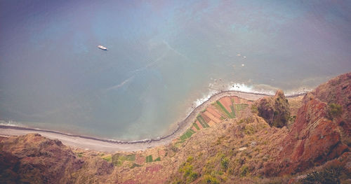 High angle view of land and sea against mountain
