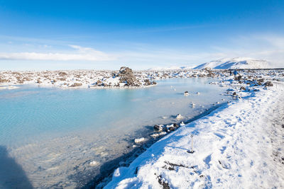 Scenic view of snowcapped mountains against blue sky