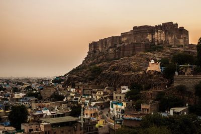 Buildings and fort against sky during sunset