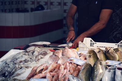 Midsection of man cutting fish