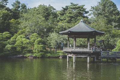 Gazebo by lake against trees