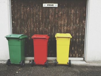 Multi colored garbage bins outside house