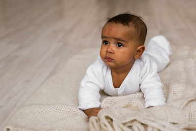 Portrait of cute baby on bed