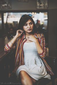 Young woman looking away while sitting outdoors