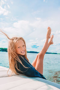 Portrait of smiling woman in sea against sky