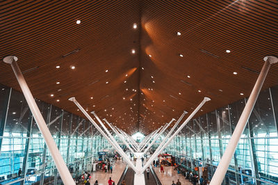 Low angle view of people at illuminated ceiling