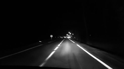 Cars on road against sky at night