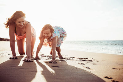 Cheerful mother and daughter at beach