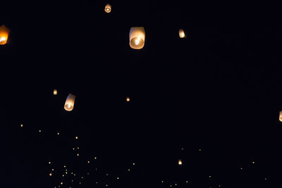 Low angle view of illuminated lights against sky at night