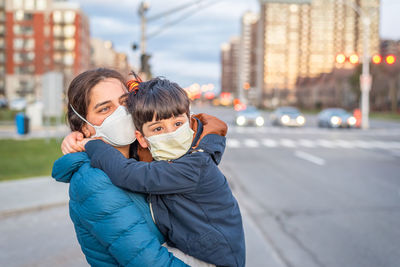 Mom and boy crossing street wearing mask during covid-19 lockdown