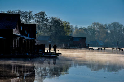 Scenic view of lake by building against sky