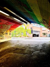 Empty road by buildings in city