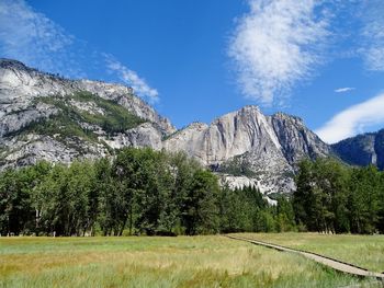 Scenic view of trees and mountains against blue sky