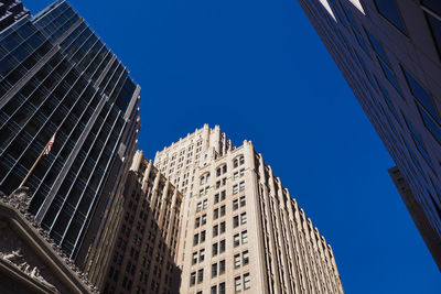 Low angle view of modern buildings against clear blue sky