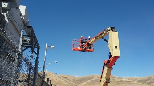 Low angle view of construction site against clear blue sky