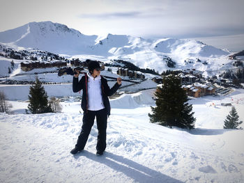 Full length of woman standing on snow covered mountain