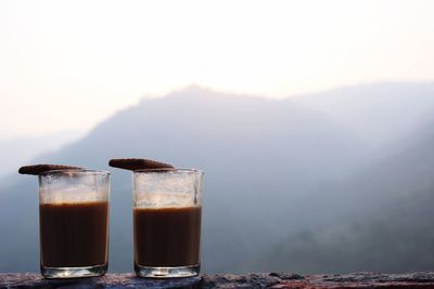 Close-up of tea and biscuits in mountains against sky