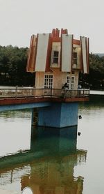 Reflection of built structure in water against sky