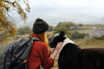 Rear view of woman looking at camera against sky