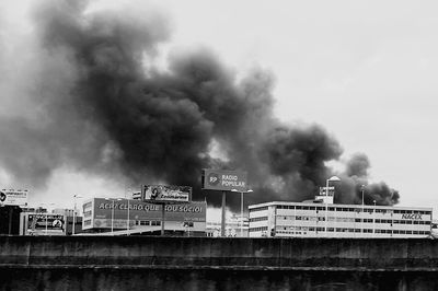 Smoke emitting from factory against sky