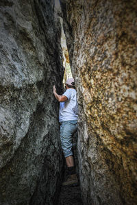 Mature woman standing amidst alley in rock formation