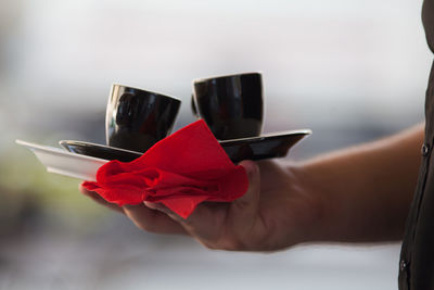 Close-up of hand holding cups