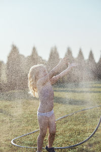 Cheerful shirtless girl enjoying at yard