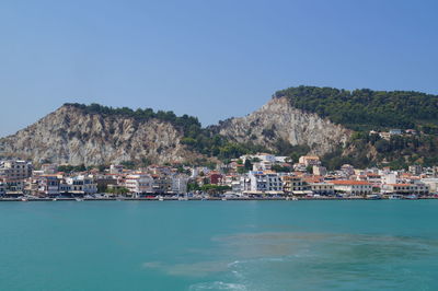 Scenic view of sea and mountains against clear blue sky