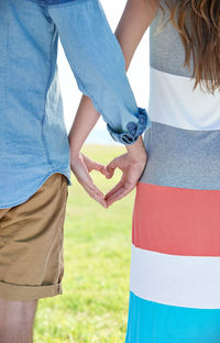 Midsection of couple holding hands