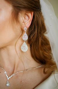 Close-up of woman wearing wedding dress and earrings 