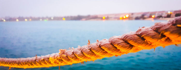 Close-up of rope at sea against sky 