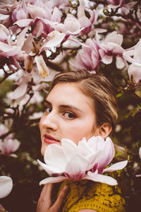 Portrait of young woman amidst pink flowers