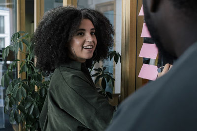 Smiling businesswoman doing meeting with male colleague at office