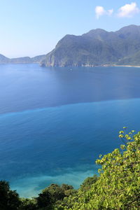 Scenic view of sea and mountains against sky