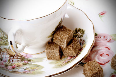 Close-up of brown sugar by cup on saucer