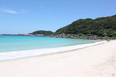 Scenic view of beach against clear blue sky