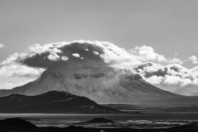 Scenic view of sea and snowcapped mountains against sky