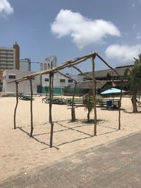 Empty chairs on beach against sky