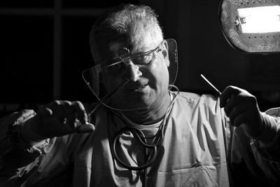 Portrait of doctor working in dark operating room